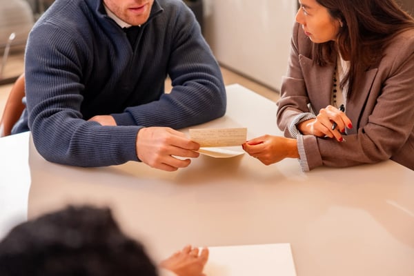 Two colleagues reviewing a note together at a table.