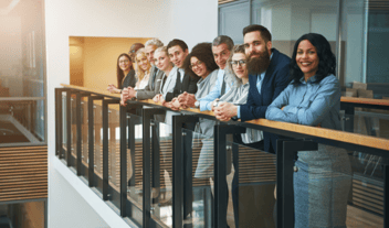 empowered-employees-standing-at-a-railing-in-their-office
