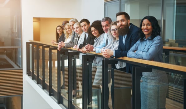 empowered-employees-standing-at-a-railing-in-their-office