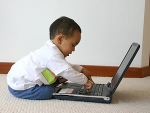 little boy playing with a laptop