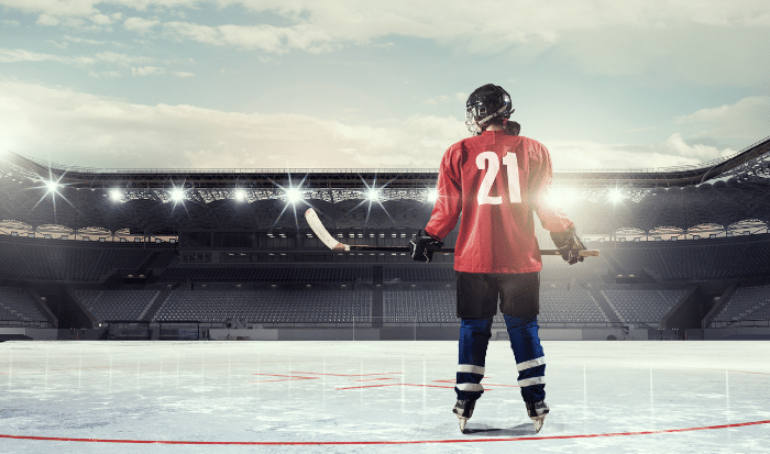 hockey-player-stands-on-ice-with-hockey-stick
