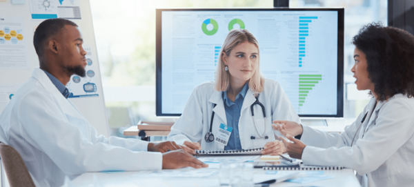 A female healthcare professional leading a staff meeting